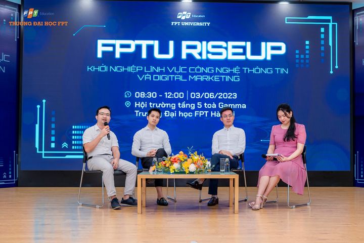 Tọa đàm bốn diễn giả trên sân khấu có màn hình lớn