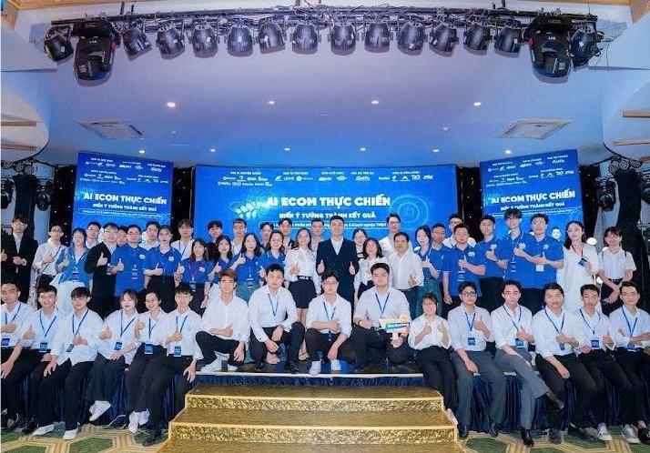 Đội ngũ và học viên mặc đồng phục xanh trên sân khấu chương trình đào tạo