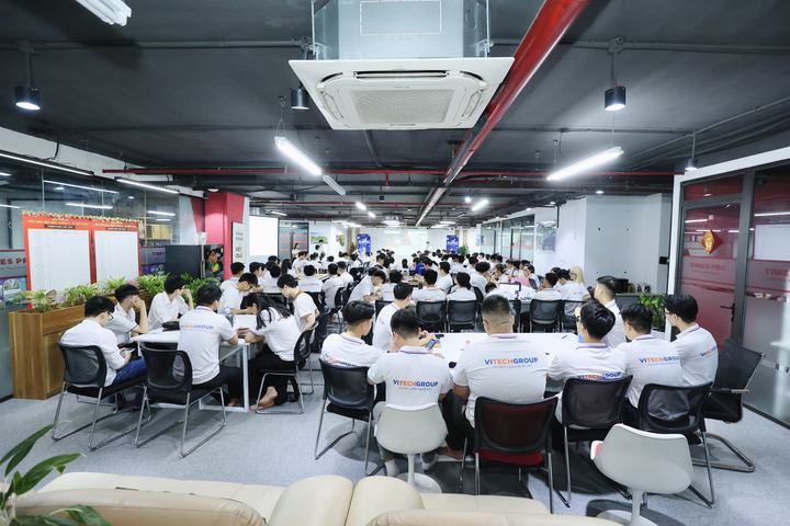 Hàng chục học viên mặc đồng phục ngồi học trong không gian văn phòng