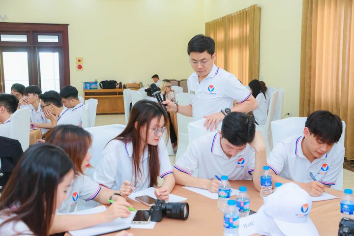 Học viên mặc đồng phục ngồi ghi chép theo nhóm trong buổi workshop