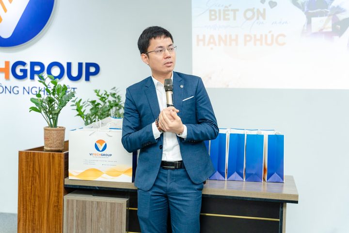Diễn giả cầm micro chia sẻ trên sân khấu