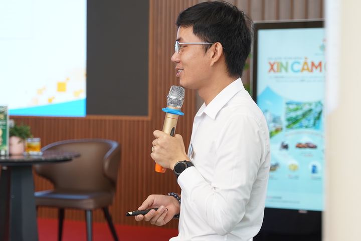 Diễn giả cầm micro, mỉm cười khi trả lời câu hỏi